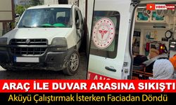 AKÜYÜ ÇALIŞTIRMAK İSTERKEN ARAÇ İLE DUVAR ARASINA SIKIŞTI